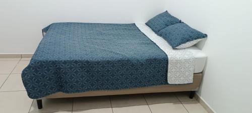 San RamónParadaHome的一张带蓝色棉被和两个枕头的床