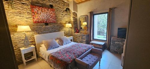 PorriDomaine COLONNA SANTINI ,Chambre d hôtes Piscine, sauna, spa的一间卧室设有一张床和石墙