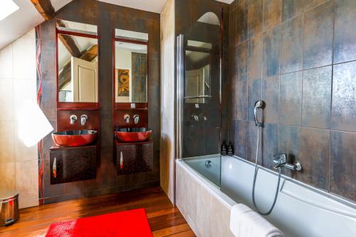 弗拉芒维尔La Villa Bel Air的浴室配有两个红色盥洗盆和浴缸。