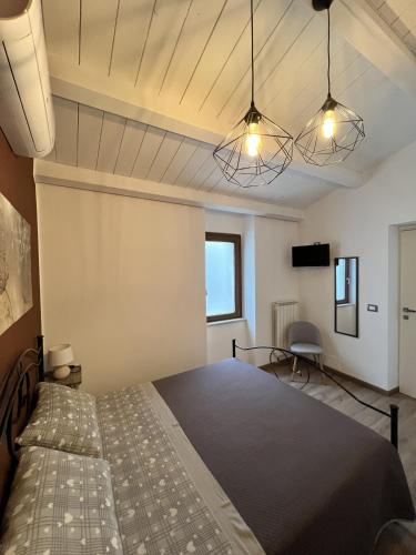 蒙泰内罗迪比萨恰Stanze Borgo Antico的一间卧室配有一张床和两个灯