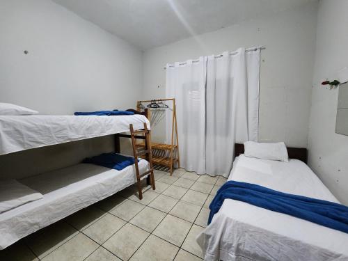 图托亚Mini Hostel的客房设有两张双层床,铺有瓷砖地板。