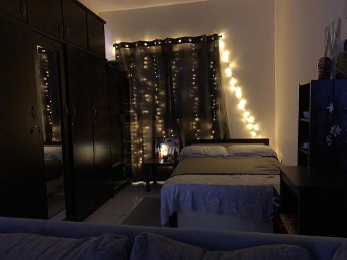 沙迦Studio Apartment的一间卧室配有两张床和带灯的窗帘