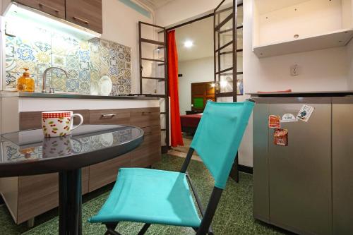 卡利Ding-Dong Hostel的厨房配有桌子和2把蓝色椅子