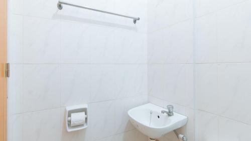 达沃市RedDoorz at Casa Buena Dormitel Davao City的白色的浴室设有水槽和卫生间。