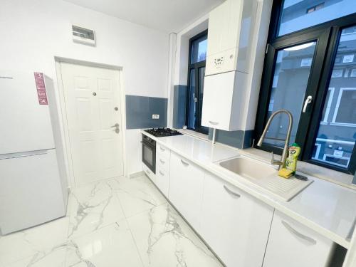 布加勒斯特Studio 9的白色的厨房设有大理石台面和窗户。