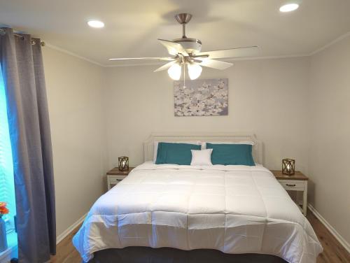 巴吞鲁日The Comfort Zone的卧室配有白色的床和吊扇