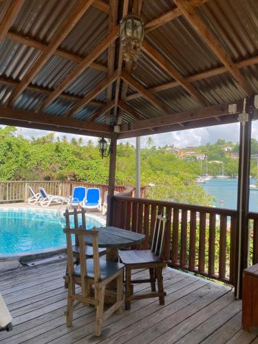 马里戈特湾Blue Bamboo cottage Marigot Bay.的一个带桌椅的甲板和一个游泳池