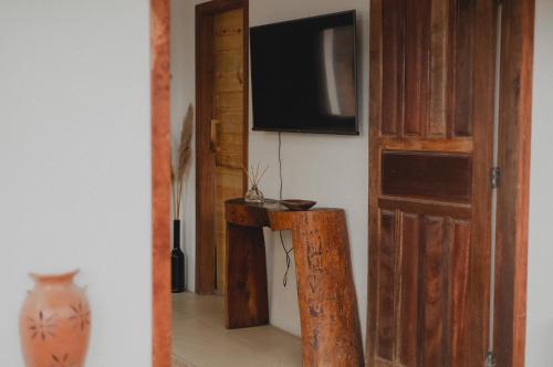 卡拉伊瓦Casinhas da Serena - Casa concha的一间配有电视的房间和一张带花瓶的桌子