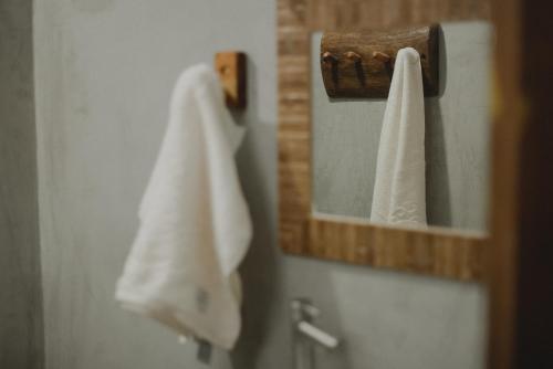 卡拉伊瓦Casinhas da Serena - Casa concha的浴室里的镜子,上面挂着毛巾