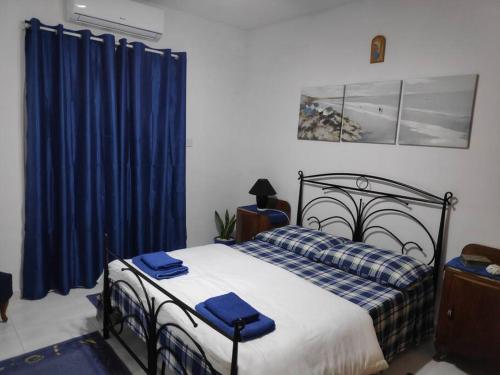 梅利哈Mellieha Bay (Ghadira) Apartment with Sea View的一间卧室配有一张蓝色窗帘的床