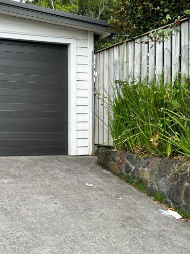 奥克兰Grey Lynn House Auckland的围栏旁房子的车库门
