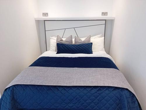 直布罗陀Urban Oasis at Luxurious Ocean Village的一张带蓝色和白色床单及枕头的床