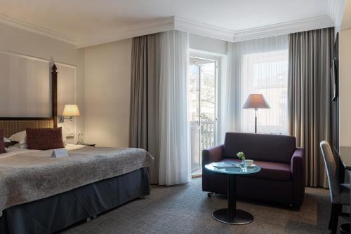 哥德堡瑞典精英酒店的配有床、椅子和桌子的酒店客房