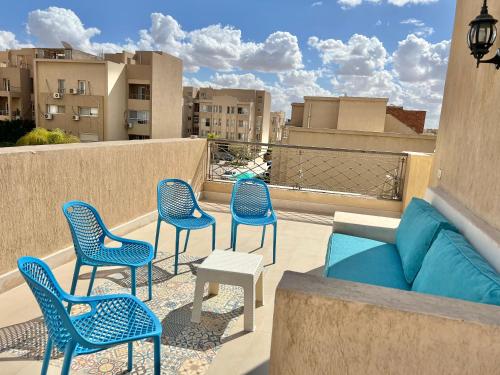 Sheikh ZayedElegant Villa in Sheikh Zayed City, Egypt - Families Only的阳台设有带椅子和沙发的庭院。