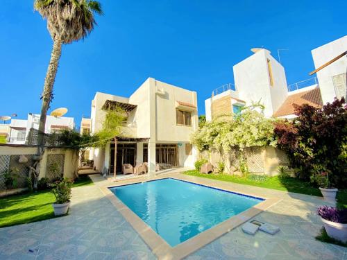 ‘Ezbet el-Ibrâshiفيلا in fayed的一座别墅,设有游泳池和棕榈树