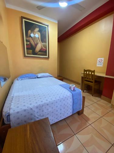 塔拉波托HOSPEDAJE Y TURISMO SOL Y LUNA EIRL的一间卧室配有一张床、一张桌子和一幅画