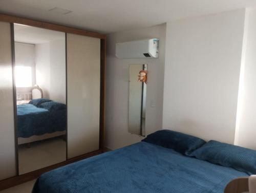 瓜拉派瑞Apart° Grande Lar的一间带镜子和蓝色床的卧室
