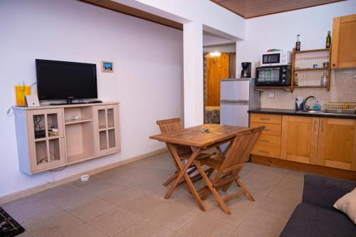 库鲁JDREAMLOC的厨房配有木桌和电视。