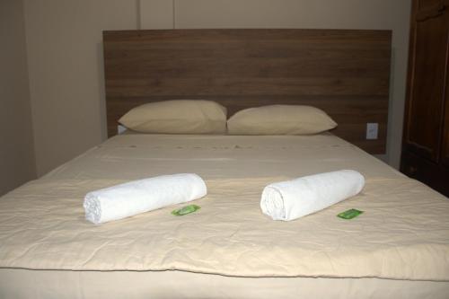 雷森迪Pé da Serra Hotel的一张带两张滚毛巾和两张拖鞋的床