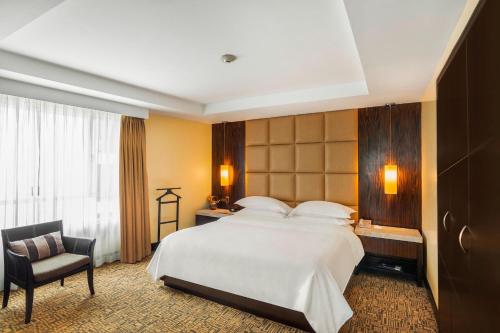 瓜亚基尔喜来登瓜亚基尔酒店的酒店客房带一张大床和一把椅子