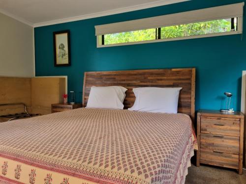 Cow Bay沃姆普生态休闲旅馆的一间卧室设有一张床和蓝色的墙壁