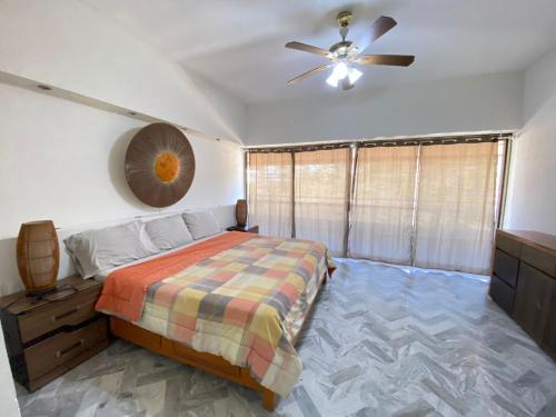 阿卡普尔科Dpto de lujo costera的一间卧室配有一张床和吊扇