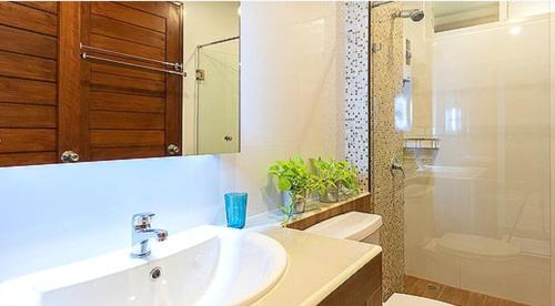 曼那Lasalle Park Serviced Apartment at Lasalle 75的一间带水槽、卫生间和淋浴的浴室