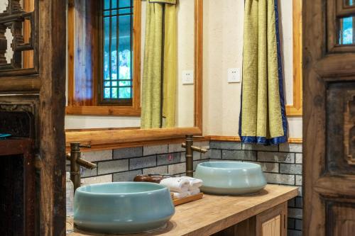 阳朔阳朔墨兰山舍酒店的浴室在柜台上设有两个蓝色水槽
