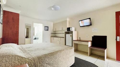 多尔比米亚尔汽车旅馆的一间卧室配有一张床、一张书桌和一台冰箱