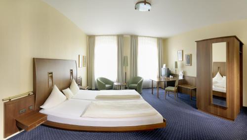 明登维多利亚酒店的酒店客房设有一张大床和一张书桌。