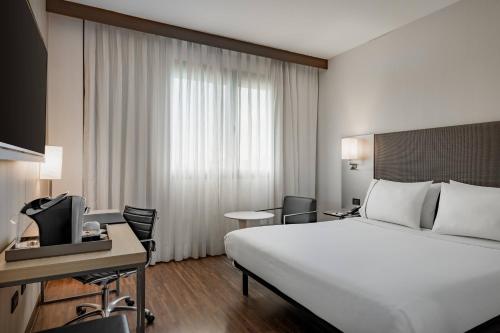 博洛尼亚博洛尼亚万豪AC酒店的酒店客房配有一张床、一张书桌和一台电视。