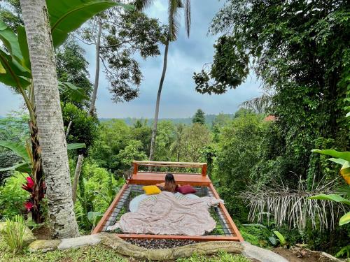 SelatKalamanthana Bali - Nature with Modern Comfort的躺在森林里床上的人
