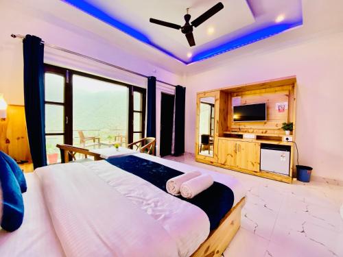 穆索里The Four Season Resort - Top Rated & Most Awarded Property in Mussoorie的一间带大床和电视的卧室