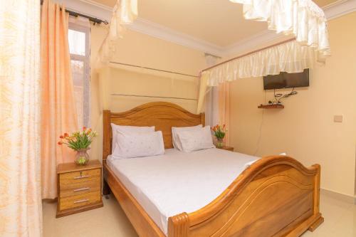 马林迪Dubai infinite luxury suites的一间卧室配有木床和电视