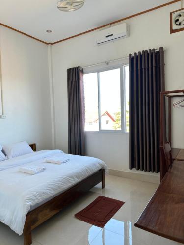 丰沙湾narixay hotel的一间卧室设有一张大床和一个窗户。