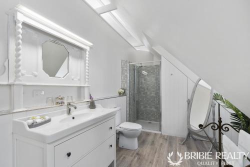 邦加里Bella Abode on Bribie - Loft with Pool的白色的浴室设有水槽和卫生间。