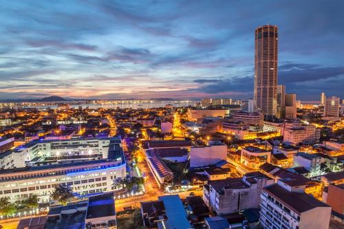 峇都丁宜MyHome Batu Feringghi Penang的城市天际线,夜晚有高耸的摩天大楼