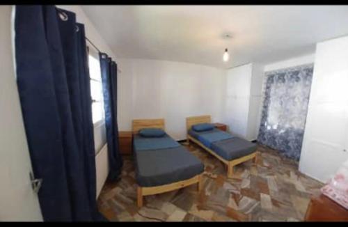 Bordj el BahriVilla Marame的一间设有两张床和一张桌子及椅子的房间