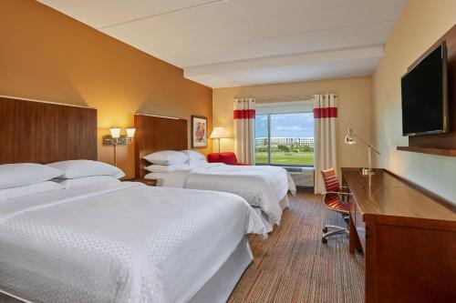 Coppell达拉斯沃思堡机场北福朋喜来登酒店 的一间酒店客房,设有三张床和一台平面电视