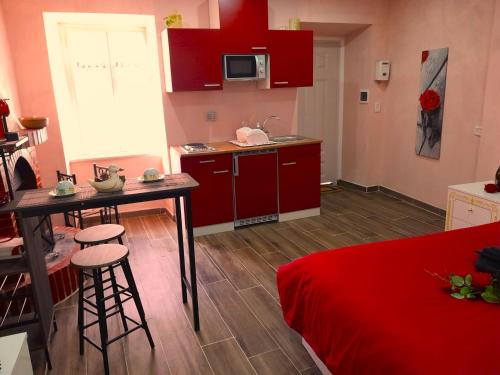 菲乌吉IL NIDO Suite的一间厨房,里面配有红色橱柜和一张桌子