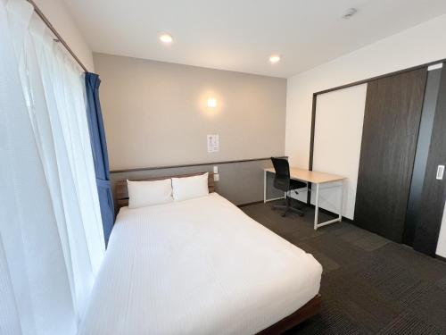 宫古岛BiBi Hotel 宮古空港前 SouthTower的配有一张床和一张书桌的酒店客房