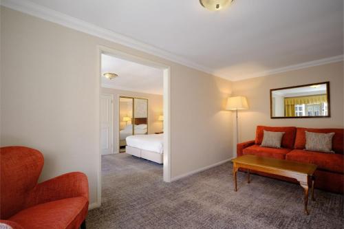 德比Delta Hotels by Marriott Breadsall Priory Country Club的客厅配有红色的沙发和床。