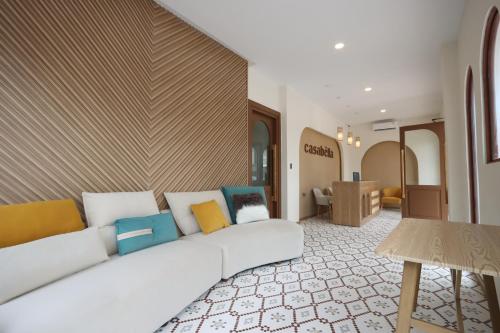 名古屋Casabella 101 A2 Grand Batam Penuin Wet Market的客厅配有带色彩缤纷枕头的白色沙发