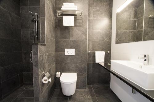 蒂尔堡巴斯琛哥罗普酒店的一间带卫生间和水槽的浴室