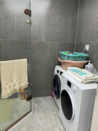 乌兰巴托Luxury Apartment at Zaisan的带淋浴的浴室内的洗衣机