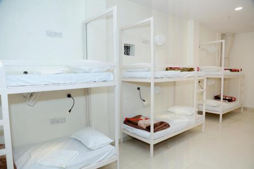 新德里Charlie's Hostel By Purple India的一间设有白色架子和白色床的房间