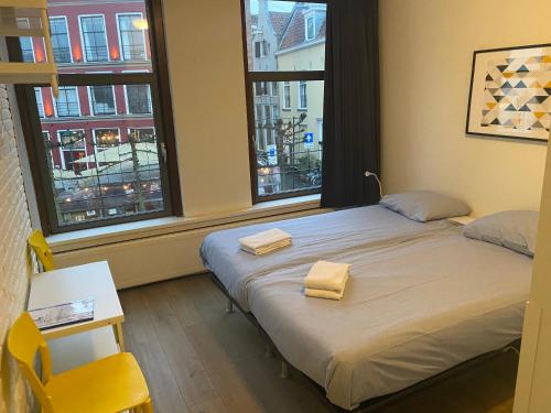 迪温特Hostel Deventer, Short Stay Deventer, hartje stad, aan de IJssel,的一间卧室配有一张床,上面有两条毛巾