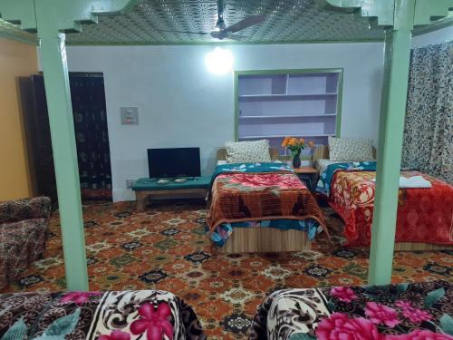 Bāgh ChandpuraRose Bowl Guest House Homestay的客房设有两张床和一张桌子上的笔记本电脑