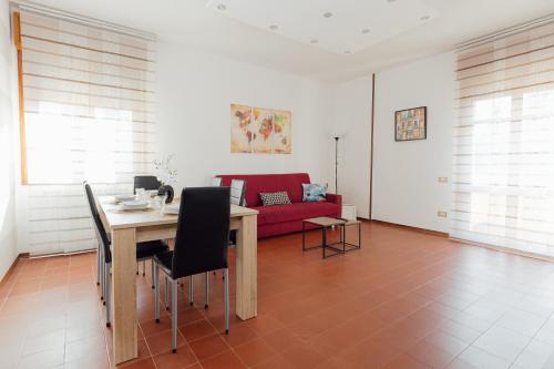 伊莫拉APPARTAMENTO ACACIA的客厅配有桌子和红色沙发