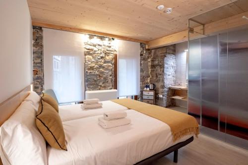 吉塔里亚Aristondo Pentsioa的卧室配有一张白色的大床和石墙